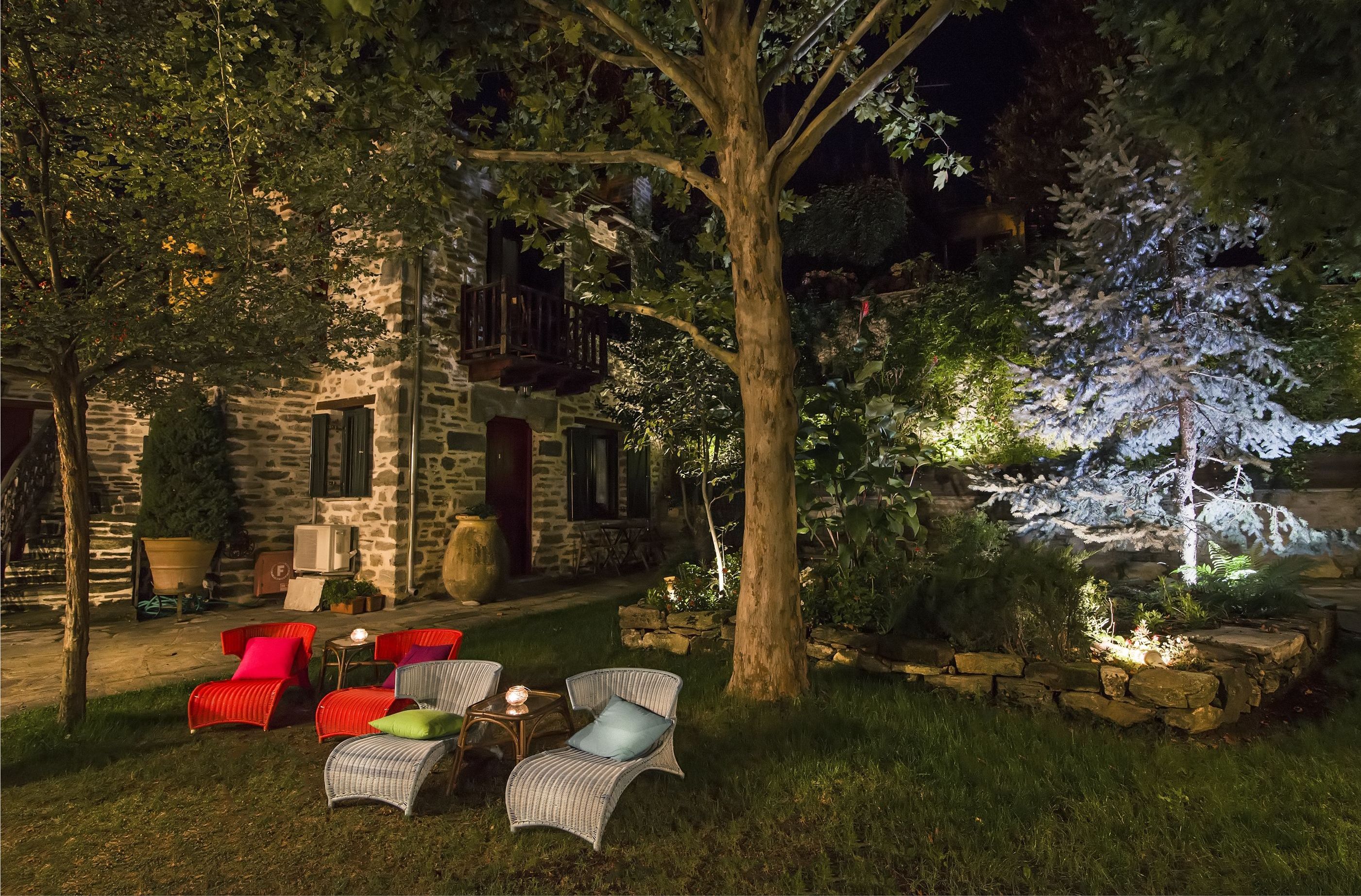 A stone building with outdoor seating and a tree.