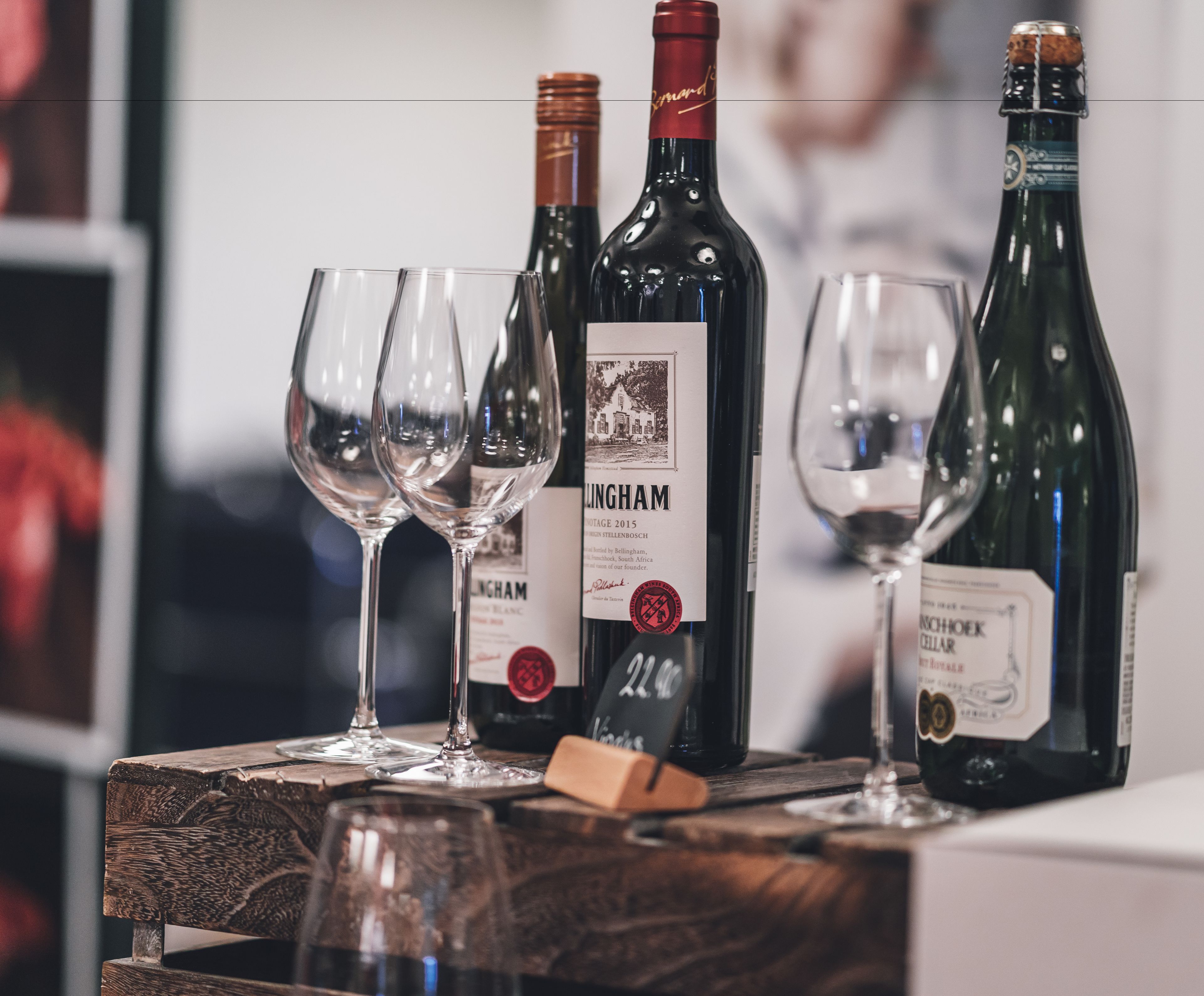 Une table en bois avec des bouteilles de vin et des verres.