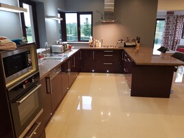 Cozinha moderna com forno embutido, micro-ondas e uma grande ilha com pia.