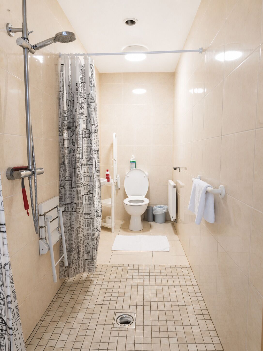 A bathroom with a shower, toilet, and towel rack.