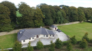 Set amidst a serene landscape, this two-story building offers a tranquil retreat with a driveway and ample windows.