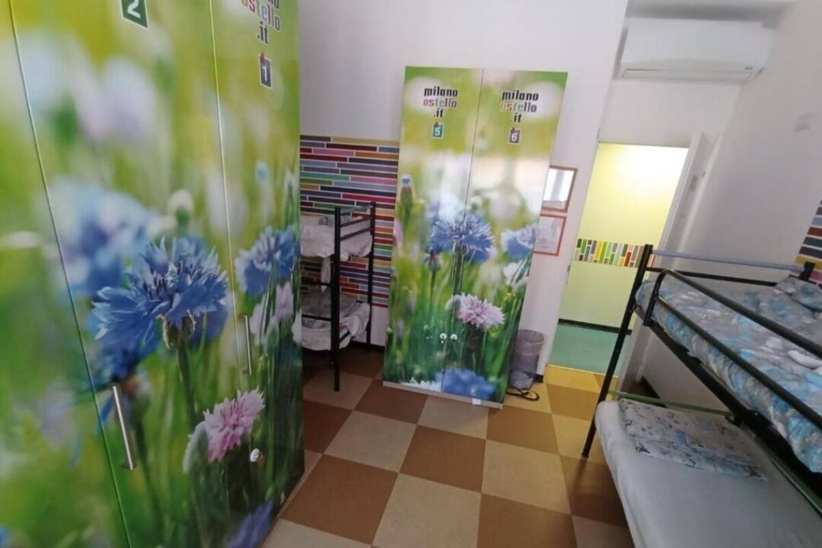 A room with bunk beds, a checkered floor, and floral posters on the walls.