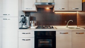 A modern kitchen with stainless steel appliances, a built-in oven, and a coffee maker.