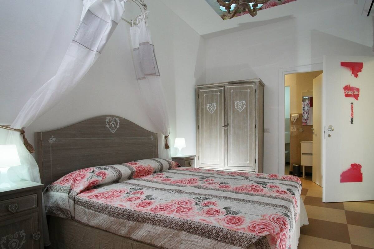 A bedroom with a bed, a wardrobe, and a door with stickers.