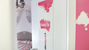 A bedroom with a bed, a door with stickers, and a chandelier. - Milano Affittacamere (Milan)