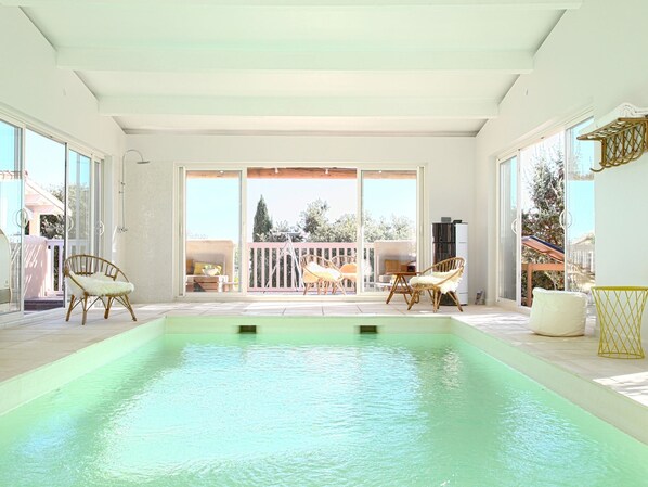 Une piscine donnant sur une terrasse aménagée avec du mobilier d’extérieur.