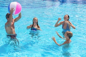 Una piscina al aire libre, sillones reclinables de piscina