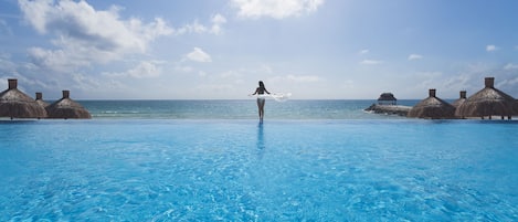 Una piscina al aire libre, sillones reclinables de piscina