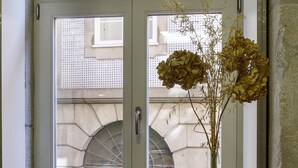 Una mesa de desayuno con diversos alimentos y un florero con flores secas junto a una ventana.