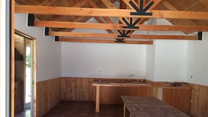 Uma cozinha compacta com armários de madeira, uma pia e uma mesa de jantar.