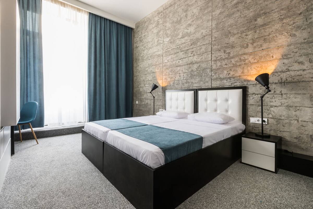 Une chambre moderne avec un grand lit, deux tables de chevet, un bureau et une chaise.