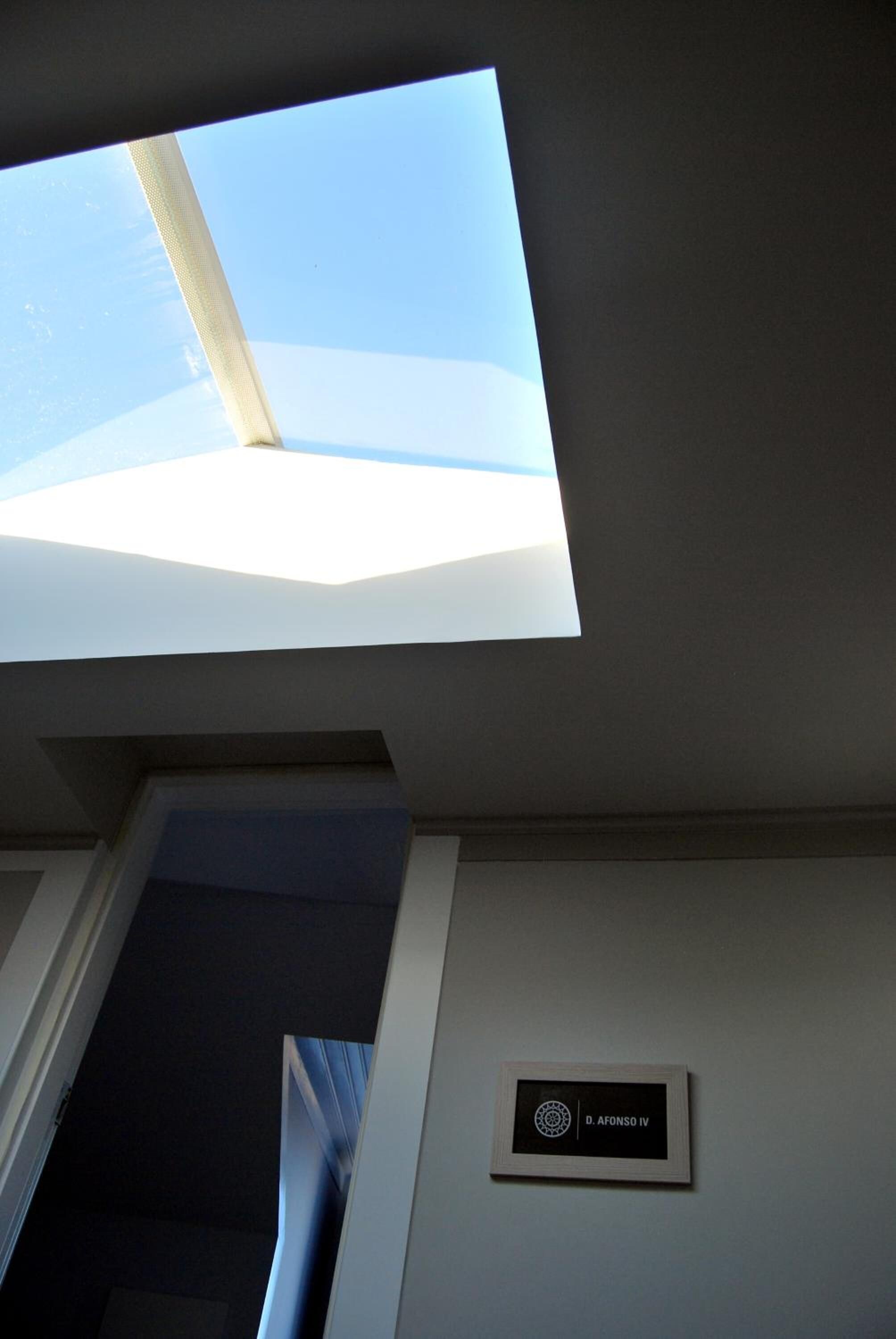 A skylight in a room with a door and a sign on the wall.