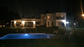 Una casa moderna de dos pisos con una piscina al frente.