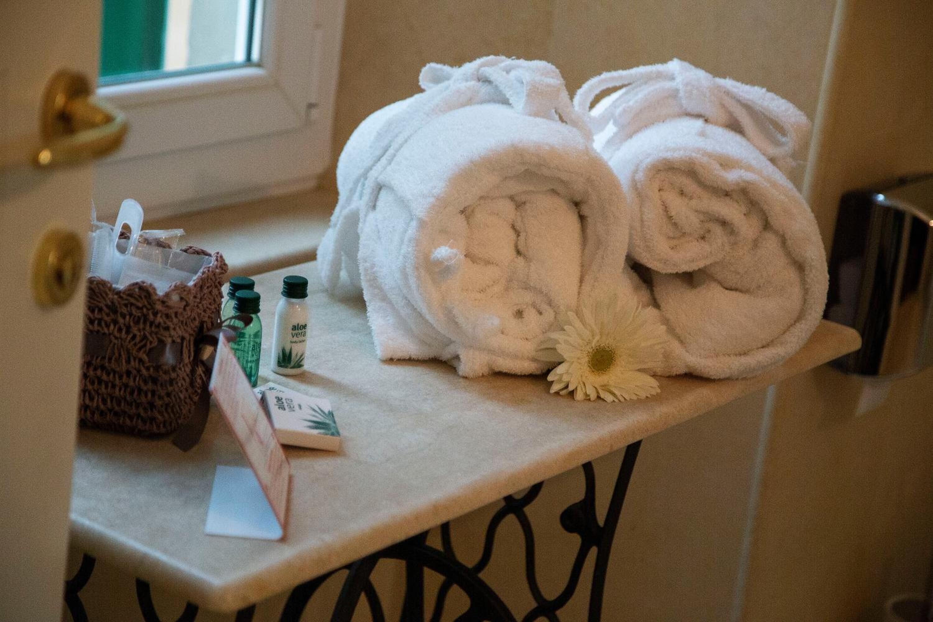 Ein Badezimmer-Anrichte mit Handtüchern, einem Korb und Toilettenartikeln.