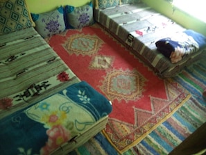 Ein Zimmer mit einer gemusterten Couch, einem roten Teppich und einem Fenster mit Blick.