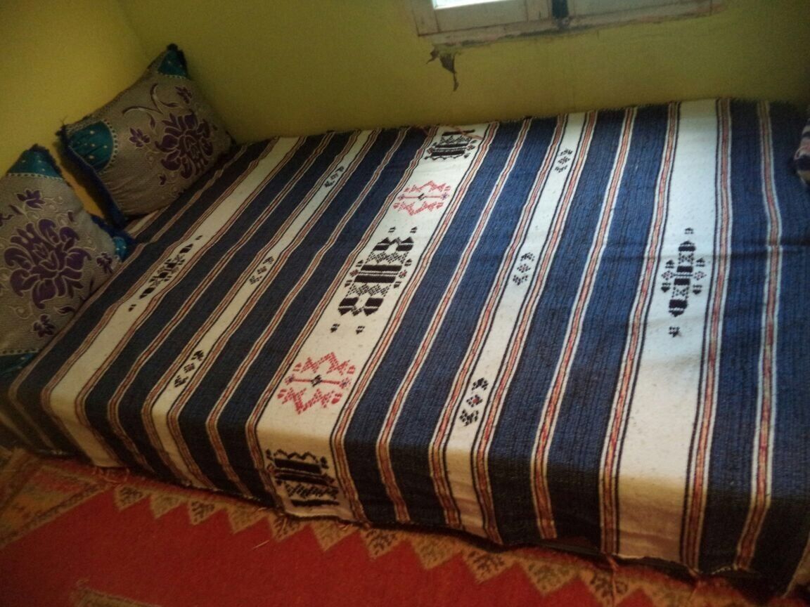 A bed with striped bedding and decorative pillows.