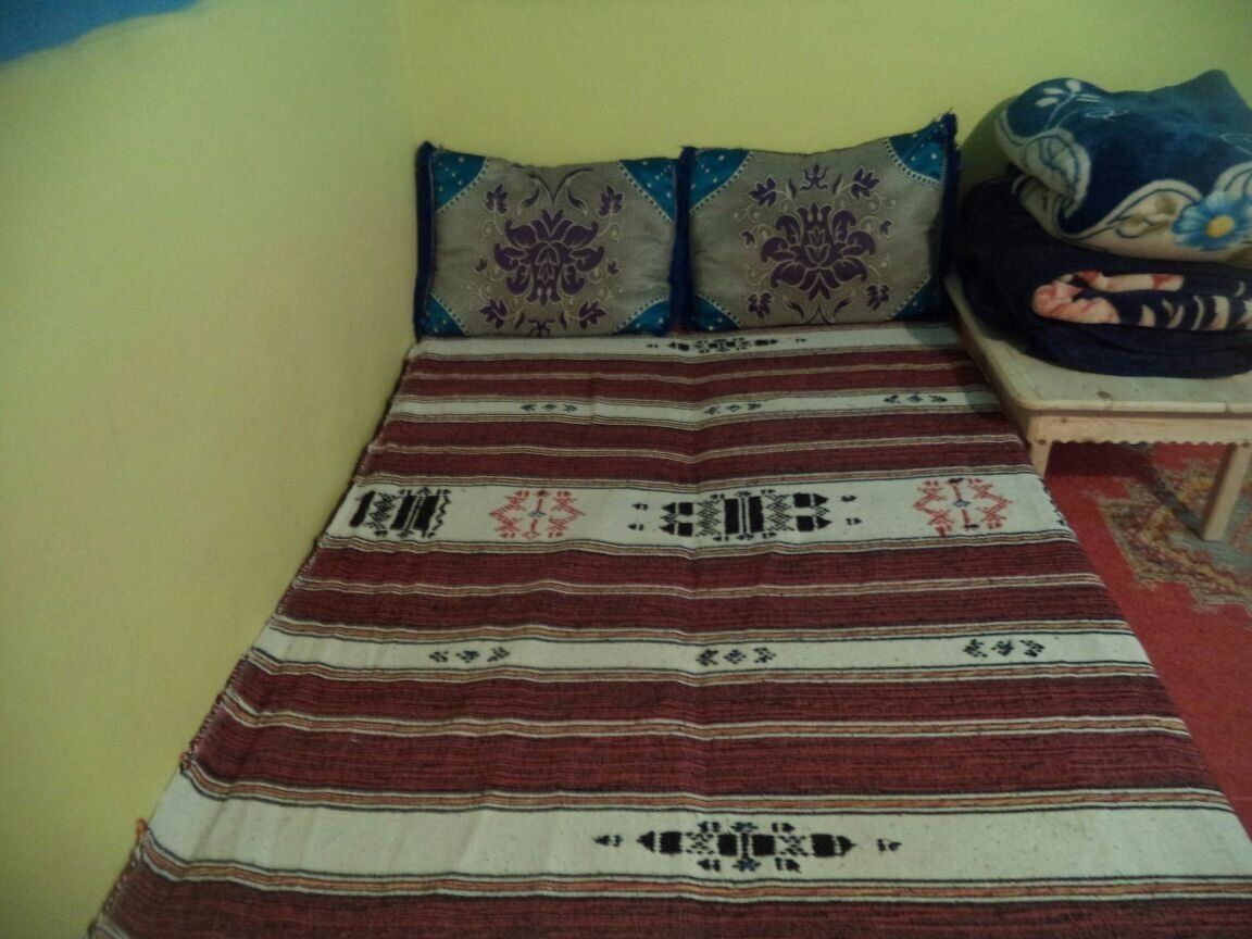 A bed with a striped blanket and decorative pillows.