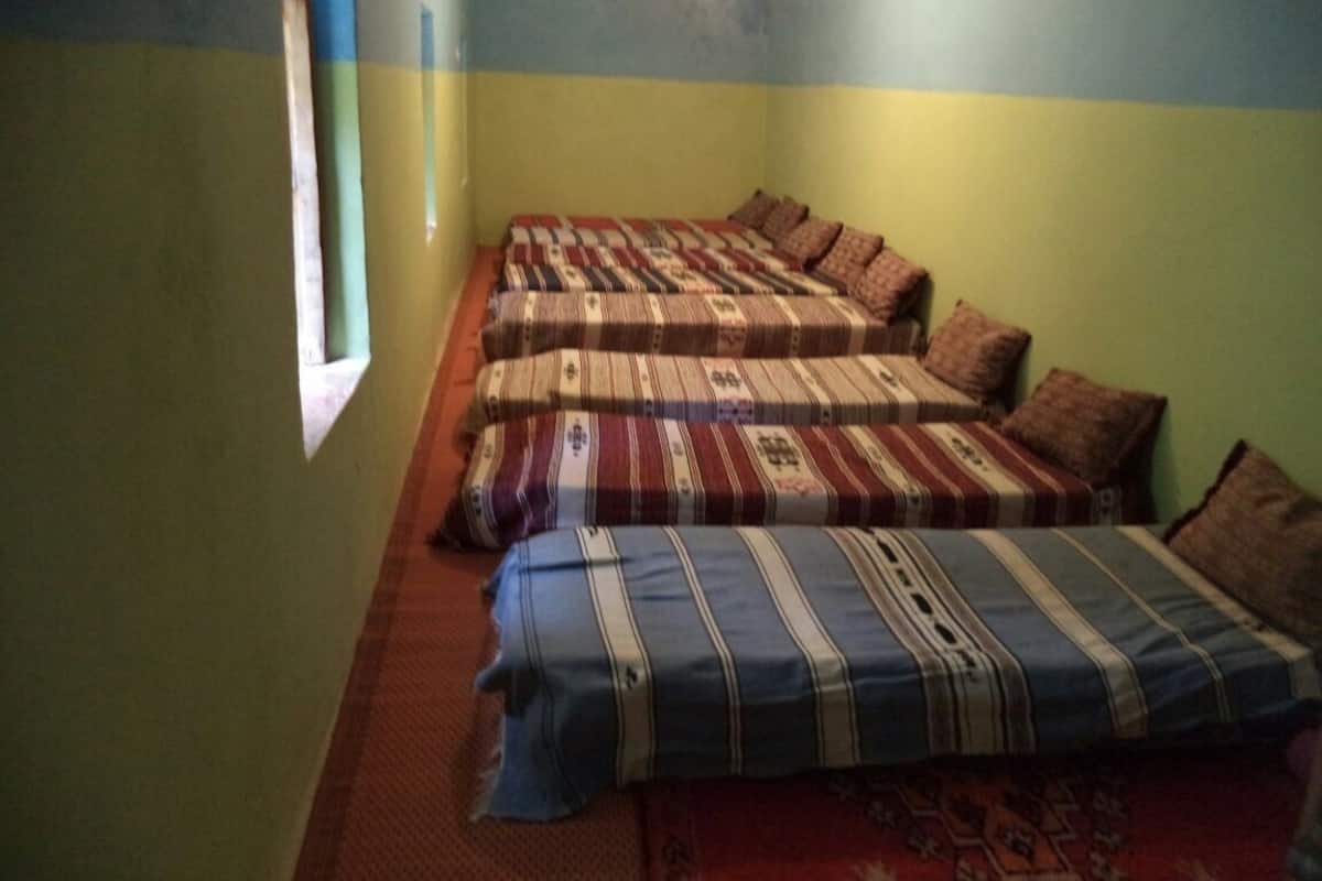 A room with two beds, a window, and a red carpet.