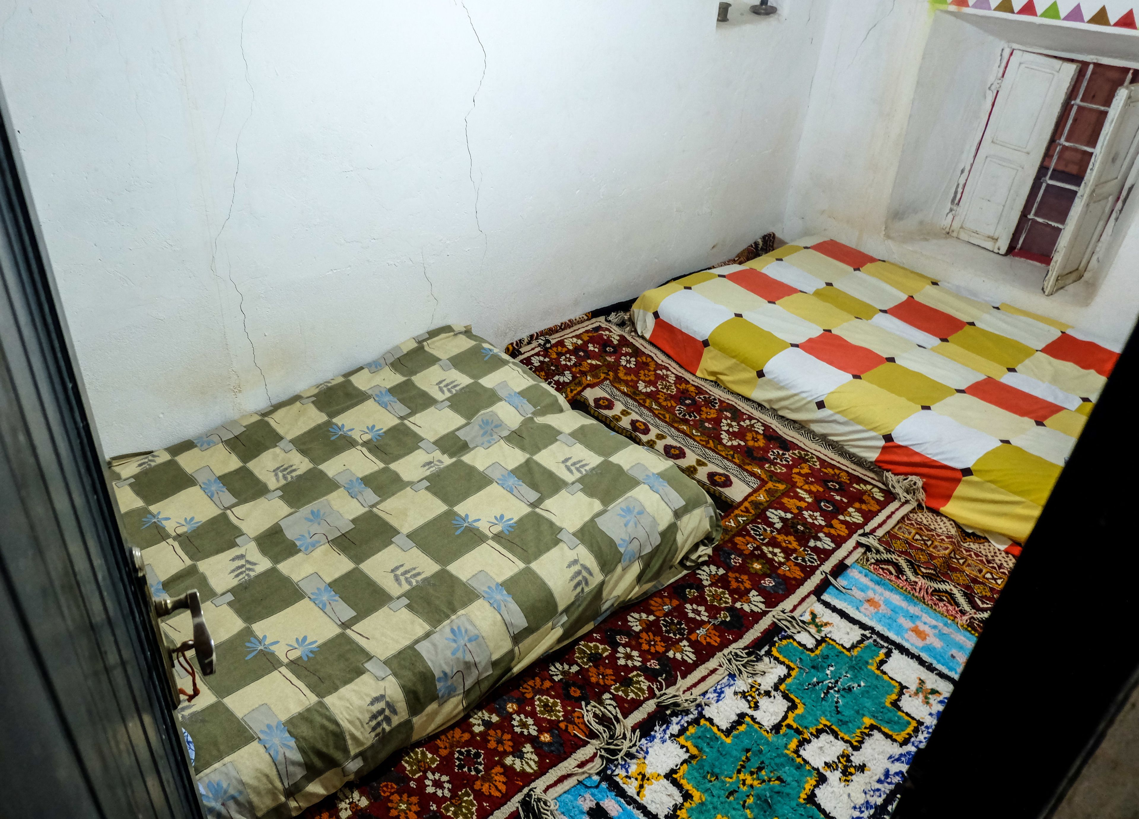 Una habitación con dos camas, cada una con un edredón de estampado diferente.
