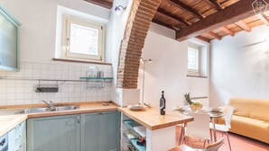 Una cocina con techo de madera, un comedor con mesa y sillas, y un sofá.