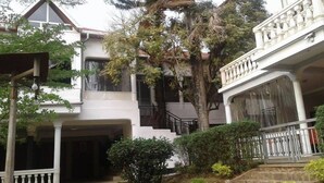 A two-story house with a balcony, a staircase, and a garden area. - Zenith Hotel Kigali (Kigali)