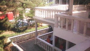 A multi-level building with balconies and railings, surrounded by greenery and trees. - Zenith Hotel Kigali (Kigali)