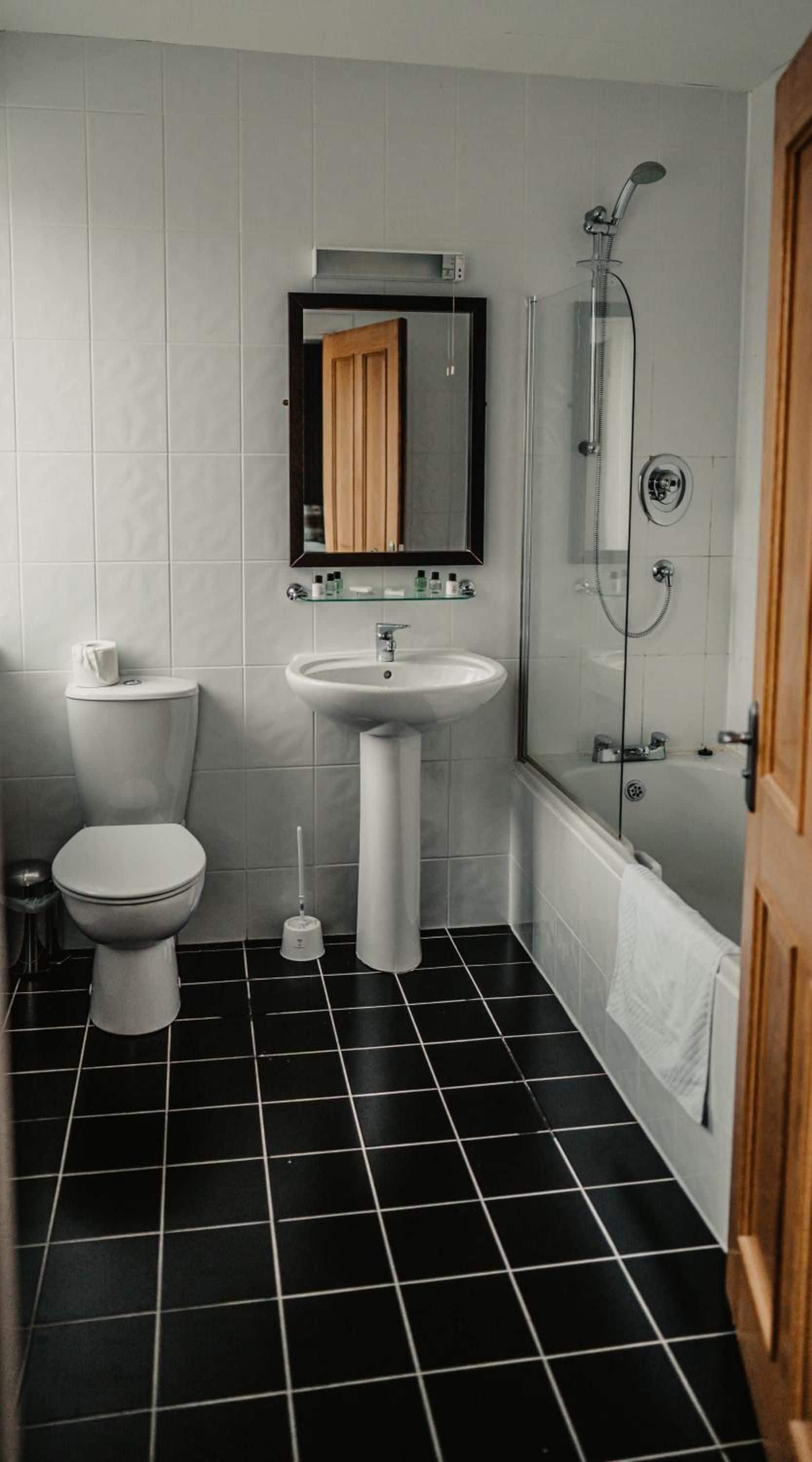 A bathroom with a toilet, sink, and shower.