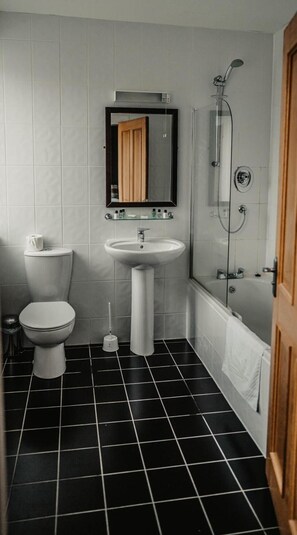 A bathroom with a toilet, sink, and shower.