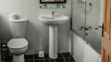 A bathroom with a toilet, sink, and shower.