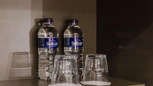 Two water bottles and three empty glasses on a shelf. - Arbor Hyde Park (London)