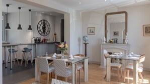A modern kitchen with a dining area, featuring a large mirror, a globe, and a clock on the wall.