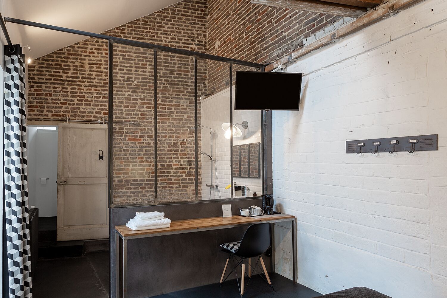 Une salle de bain moderne avec un meuble-lavabo en bois, une chaise noire et un miroir.