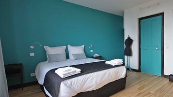 A bedroom with a bed, a dresser, a wardrobe, and a mannequin.