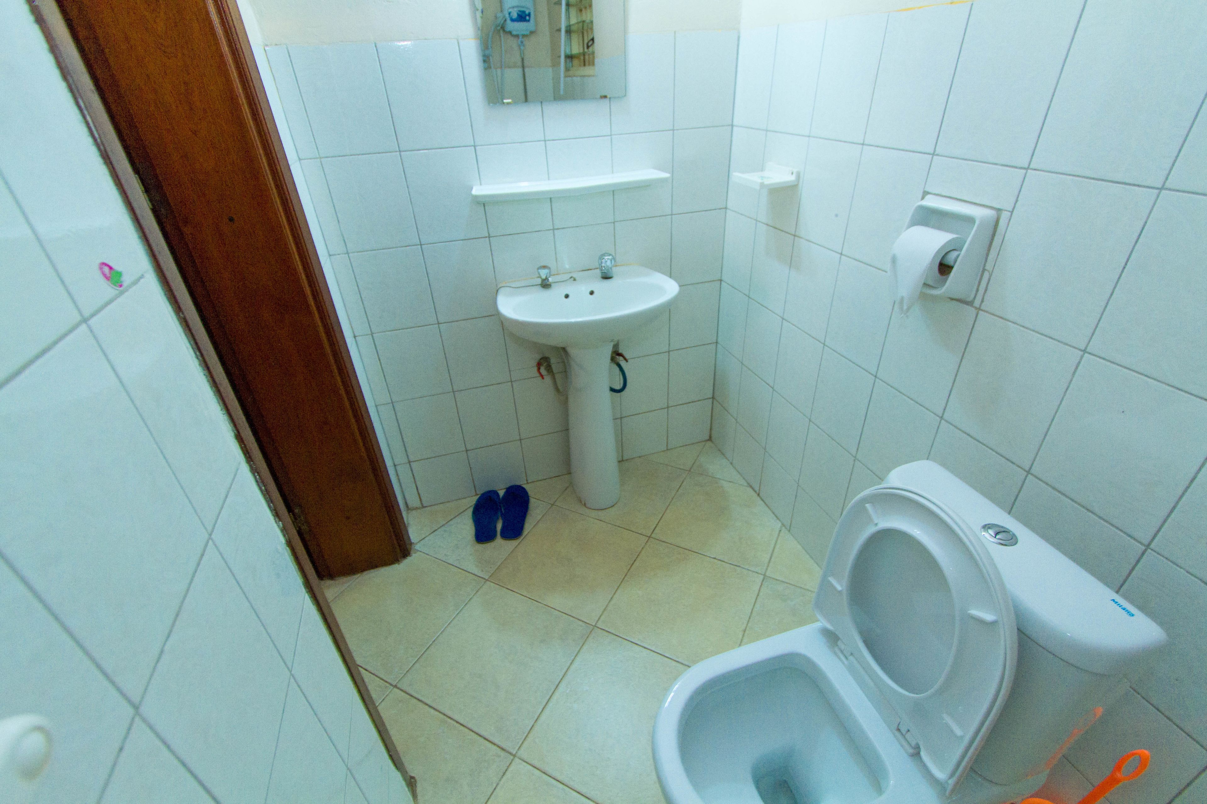A small bathroom with a toilet, sink, and a mirror above the sink.