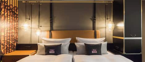 Una cama doble con cabecera, dos mesitas de noche y una pared con diseño decorativo.