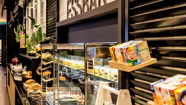 A bakery display with various baked goods and a refrigerated section. - Holiday Inn - the niu, Cobbles Essen by IHG (Essen)
