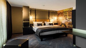 A modern hotel room with a large bed, bedside tables, a desk, and a decorative wall. - Holiday Inn - the niu, Cobbles Essen by IHG (Essen)