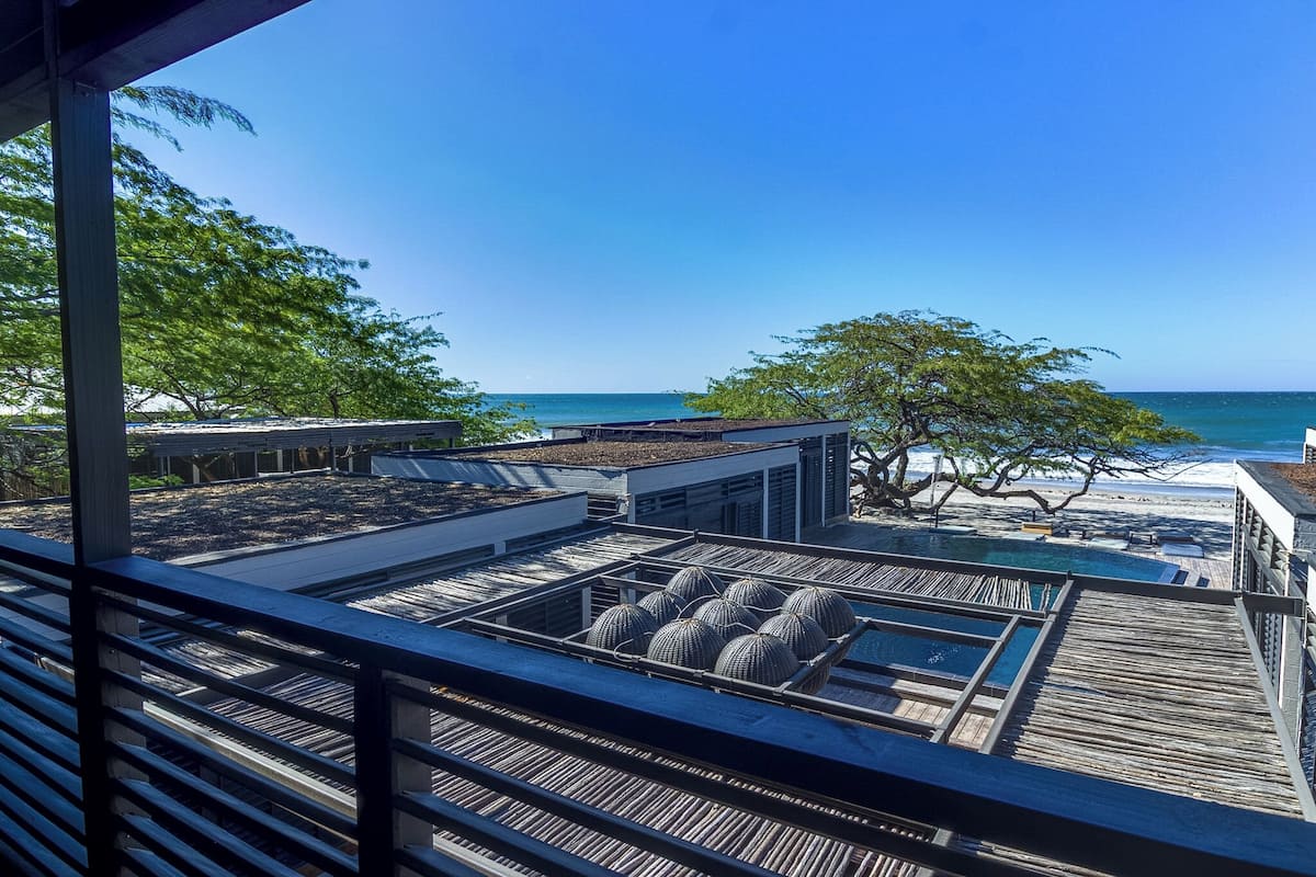 A rooftop terrace with a pool, wooden deck, and ocean view.