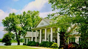 A large, two-story house with a symmetrical facade, large columns supporting a porch, and a well-maintained lawn. - The B & B at Queenslake (Georgetown)