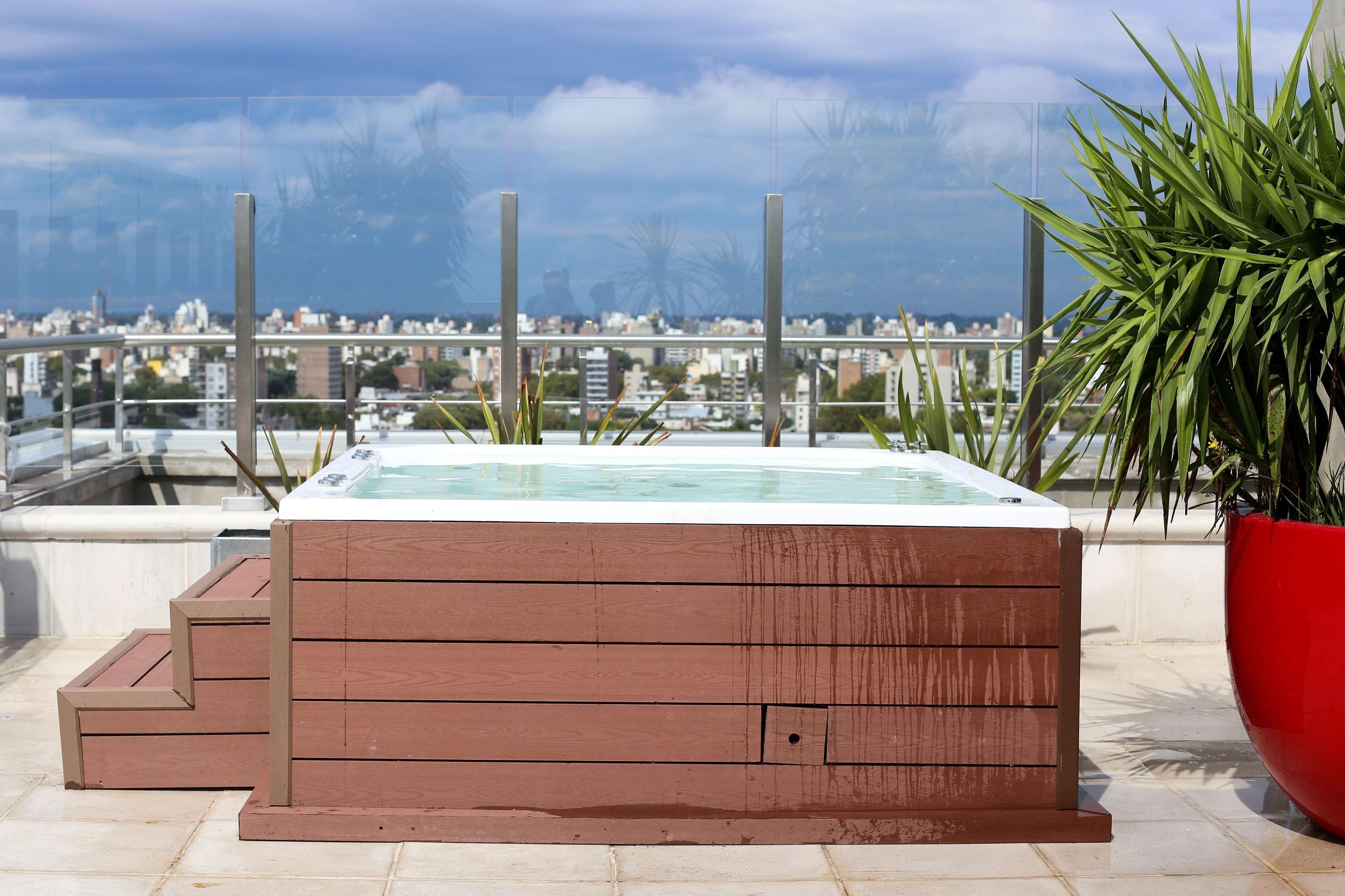 A hot tub on a rooftop terrace with a city view.