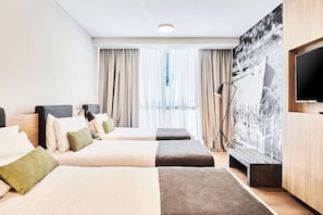 A modern hotel room with two beds, a large window with curtains, a flat-screen TV, and a large artwork on the wall. - Dazzler by Wyndham Rosario (Rosario)