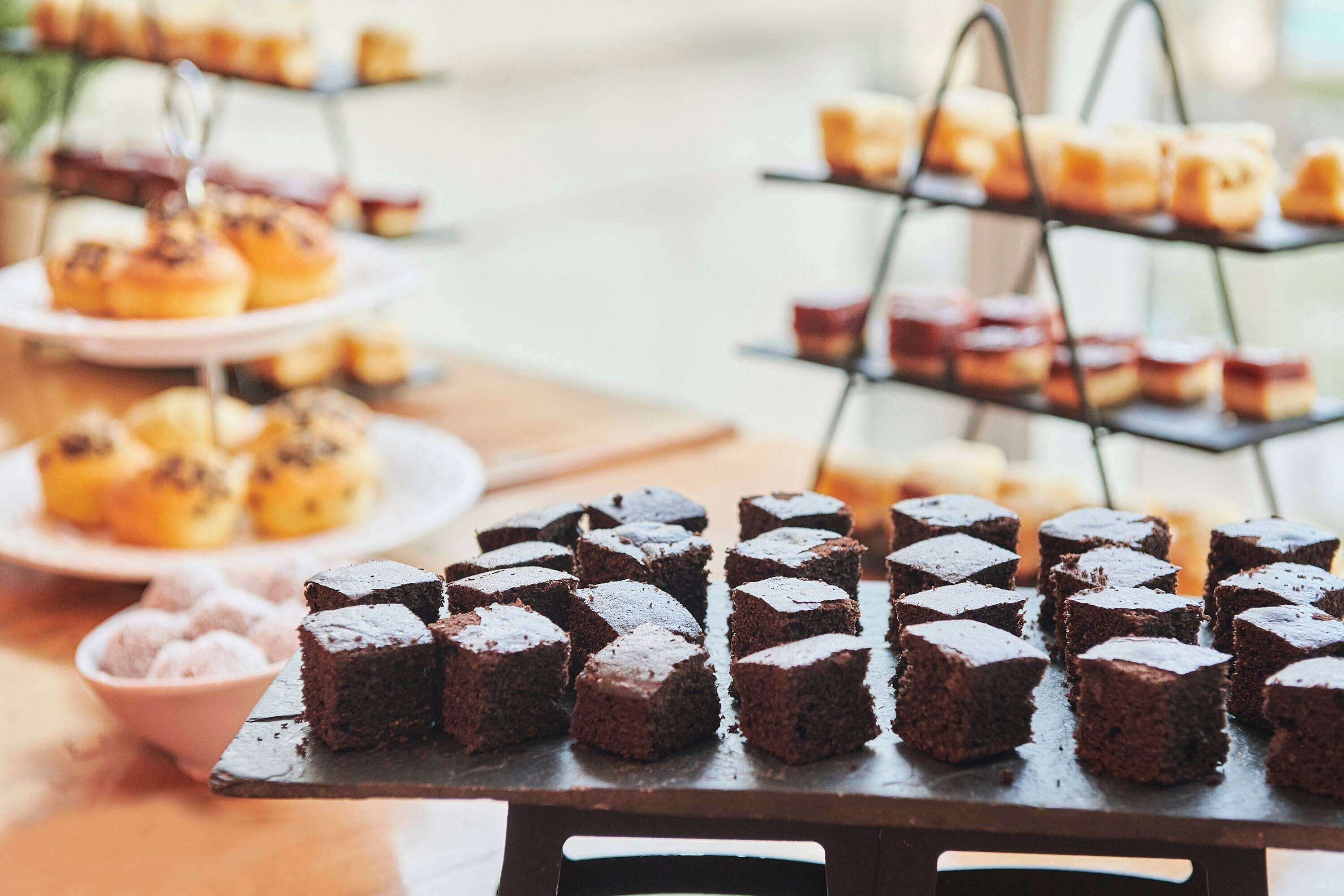A dessert table with various baked goods, including brownies and pastries.