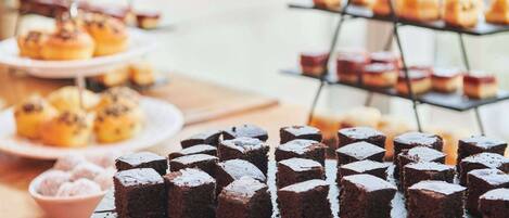 A dessert table with various baked goods, including brownies and pastries.