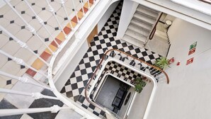 A checkered floor with a staircase leading to a lower level. - Hostel Malaga City (Malaga)