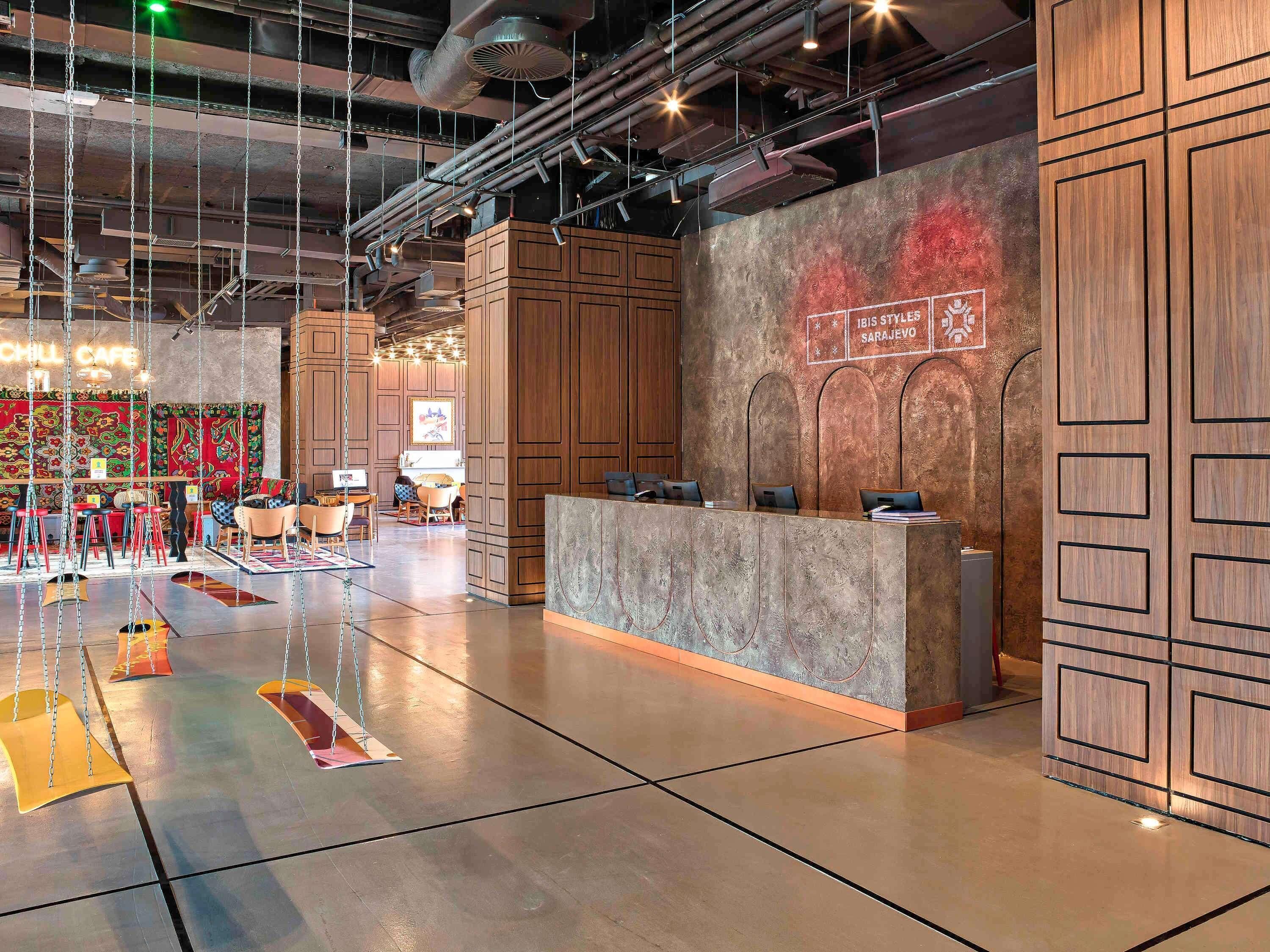 A modern interior with a reception desk, seating area, and a colorful mural.
