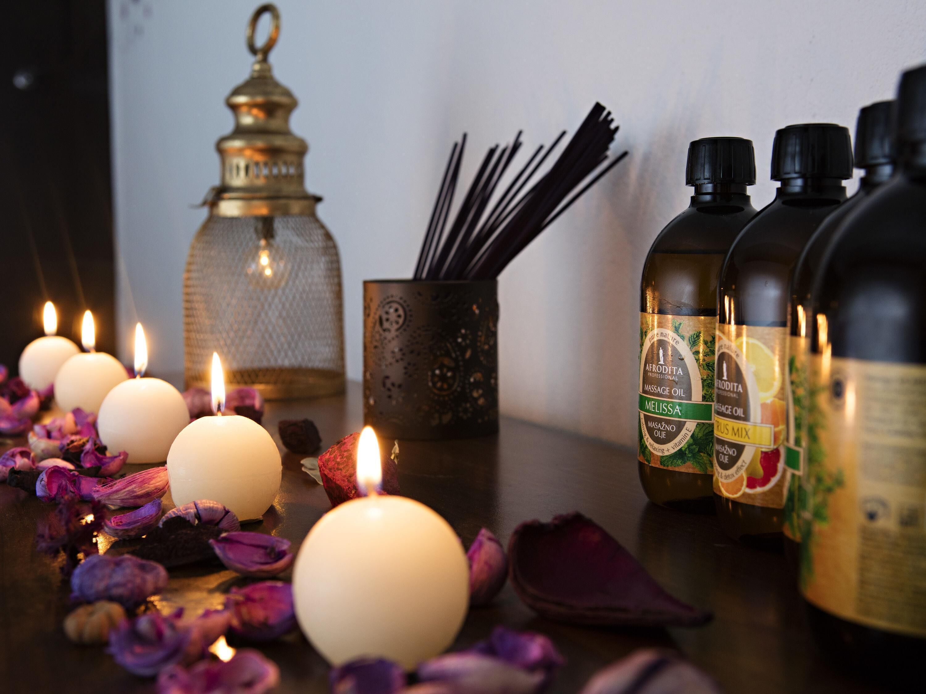 Candles, essential oils, and a decorative lantern on a table.