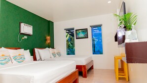 A hotel room with a bed, a small desk, a plant, and two windows with views of the outdoors. - Den'gi Inn (El Nido)