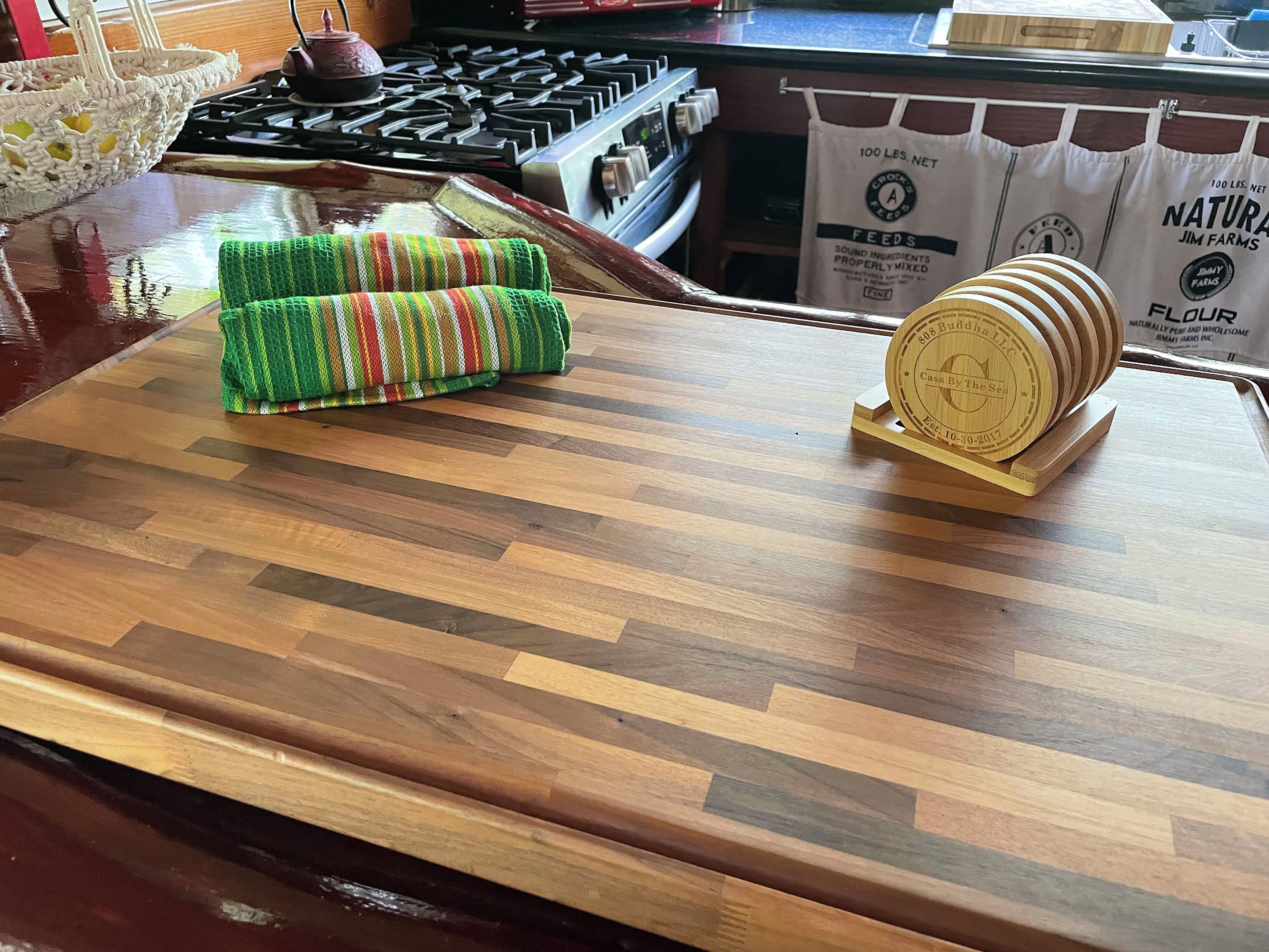 A kitchen counter with a woven placemat, a wooden coaster, and a bag of flour.