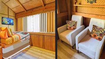 Cozy room with a comfortable bed, flat-screen TV, and armchairs for relaxing.