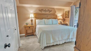 A bedroom with a bed, nightstands, a decorative headboard, and a door. - two bedroom condo sleeps 4 persons (Gatlinburg)